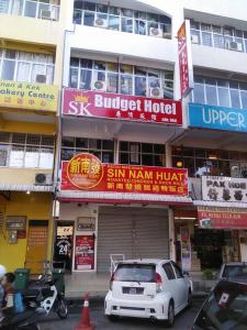 a white car parked in front of a building at SK Budget Hotel in Jelutong