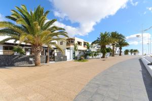 una calle con palmeras y edificios blancos en Salitre, en Playa Honda