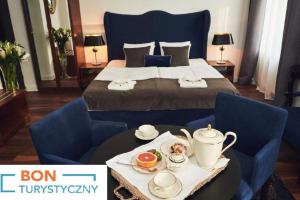 een hotelkamer met een bed en een dienblad met eten op een tafel bij Shalom Kazimierz in Krakau