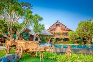 a resort with a wooden wagon in front of a pool at Prangpaya Khaoyai in Pak Chong