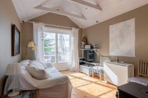 a living room with a white couch and a window at Vaxholm Seaview Cottage in Vaxholm