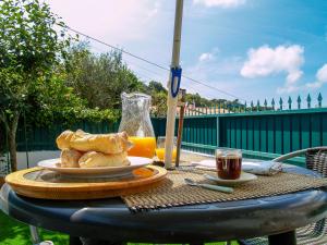 a table with a plate of bread and a glass of orange juice at Apartamento Sintra in Sintra