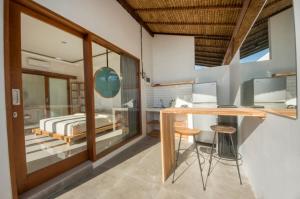 a bedroom with a bed and a desk with a computer at Kiki Village Private Villas in Canggu