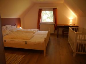 Schlafzimmer mit einem Bett, einem Schreibtisch und einem Fenster in der Unterkunft Ferienhaus am Nordseedeich in Alleinlage in Hooksiel