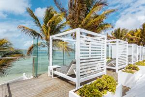 een witte pergola op een terras met uitzicht op de oceaan bij Tropical Attitude (Adults Only) in Trou dʼ Eau Douce