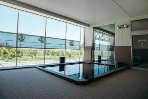 a large building with a swimming pool in front of windows at SORA RINKU in Sennan