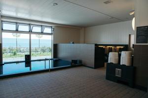 a bathroom with a swimming pool and a large window at SORA RINKU in Sennan