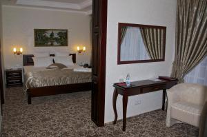 a bedroom with a bed and a dresser at Slava Hotel in Zaporozhye