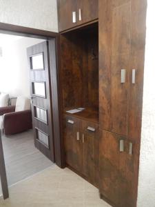 a large wooden cabinet in a living room at LERA APARTMENT in Burgas