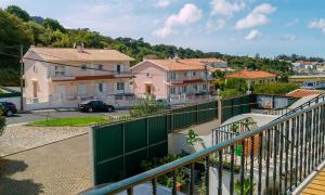 einen Balkon mit einem grünen Zaun und Häusern in der Unterkunft Apartamento Sintra in Sintra