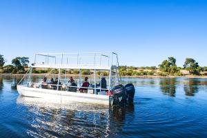un grupo de personas en un barco en el agua en Chobe River Campsite, en Ngoma
