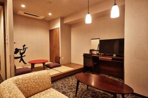 a living room with a couch and a flat screen tv at Y's Inn Naha Oroku Ekimae in Naha