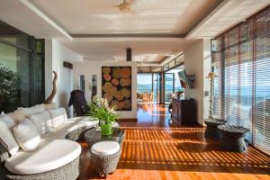Baan View Talay في بانبانغْ بو: غرفة معيشة مع أريكة بيضاء وبعض النوافذ