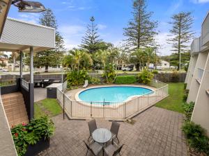 a patio with a pool and a table and chairs at Yamba Sun Motel in Yamba