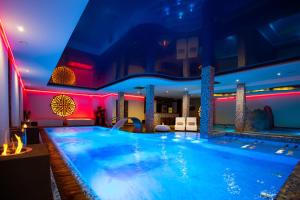 a large swimming pool in a hotel with red lights at Hotel Piwniczna SPA&Conference in Piwniczna-Zdrój