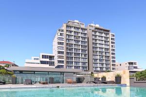 a large building with a swimming pool in front of a building at Infinity 602 in Bloubergstrand