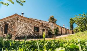 een oud stenen gebouw aan de zijkant van een heuvel bij Lagar de Viña Vieja in Cazalla de la Sierra