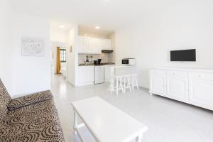 a kitchen and living room with a couch and a table at Apartamentos Aloe in Puerto del Carmen