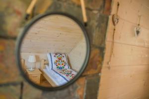 uno specchio che riflette una stanza con panchina in una stanza di Świerkowy Raj a Ustroń