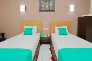 מיטה או מיטות בחדר ב-Hotel Lestari Near Lippo Plaza Mall Jember Mitra RedDoorz