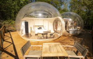 a house in a glass dome with a table and chairs at Ursa Major Bubble in Camporgiano