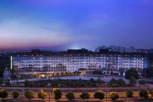 duży budynek jest oświetlony w nocy w obiekcie Novotel Nanjing East Suning w mieście Nankin