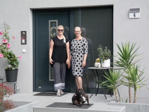 ラドルフツェル・アム・ボーデンゼーにあるFerienwohnungen Dianaの二人の女が犬を連れてドアの前に立っている