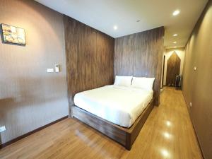 a bed in a room with a wooden wall at Baan Keang Chon Ayutthaya บ้านเคียงชล อยุธยา in Phra Nakhon Si Ayutthaya