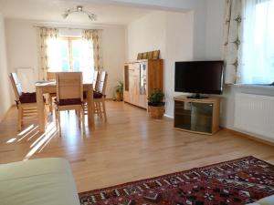 a living room with a television and a dining room at Ferienhaus Anke - Ausseerland Salzkammergut in Pichl bei Aussee