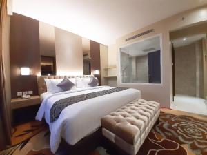 a large bedroom with a large bed and a bath tub at ASTON Gorontalo Hotel & Villas in Gorontalo