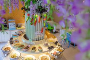 einen Tisch mit Teller mit Lebensmitteln und eine Vase mit Blumen in der Unterkunft Merryseasons in Kaohsiung