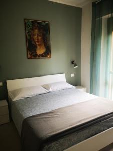 1 dormitorio con 1 cama con una pintura en la pared en Il Giardino di Anna - Charming rooms in Cagliari en Cagliari