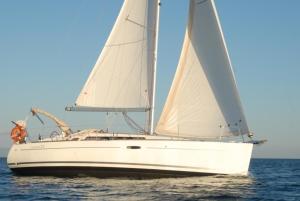 a white sailboat on the water with a man on it at Boat & Sailing Torregrande Sinis Yachting in Oristano