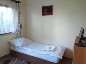 a small bed in a room with a window at Zajazd Joniec Małgorzata in Dobra