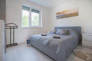 ein Schlafzimmer mit einem großen Bett in einem weißen Zimmer in der Unterkunft Panoráma Apartman Tiszafüred in Tiszafüred