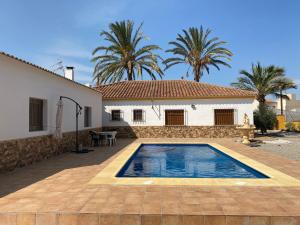 a villa with a swimming pool in front of a house at Chalet con piscina privada de 4 dormitorios Las Herrerias -cerca de Vera Playa- in Cuevas del Almanzora