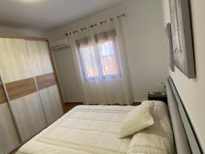 una camera da letto con un letto grande davanti a una finestra di Chalet con piscina privada de 4 dormitorios Las Herrerias -cerca de Vera Playa- a Cuevas del Almanzora Altre 23 foto