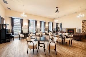 a room with tables and chairs and a fireplace at Wine & Wellness hotel Besední dům in Valtice