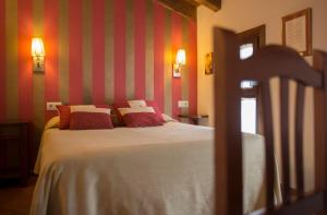 a bedroom with a bed with red and white stripes at El Lagar del Vero in Huerta de Vero