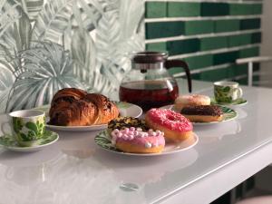 drie borden donuts op een tafel met kopjes koffie bij Jungle Apartments in Vinnytsya