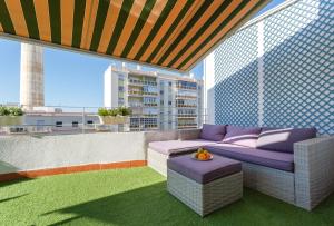 balcón con sofá púrpura en el techo en Atico La JOYITA free parking by Cadiz4Rentals, en Cádiz