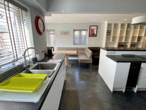 uma cozinha com um lavatório e uma sala de estar em Southernwood - Wantage Road House em Didcot