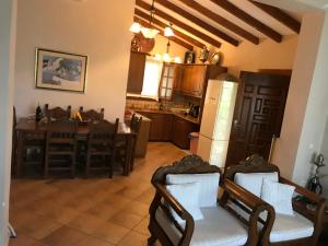 kuchnia i salon ze stołem i krzesłami w obiekcie Villa Maroudia w mieście Kími