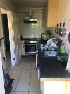 a kitchen with a sink and a stove at Double Room with Private Bathroom in a 2-bedrooms house in London