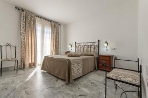 a bedroom with a bed and a dresser and a window at Hotel La Parrita in Rota