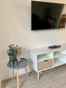 ein Wohnzimmer mit einem Tisch und einem TV an der Wand in der Unterkunft Amaya Three - Newly Renovated - Sleeps 6 - Grantham in Grantham