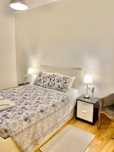1 dormitorio con 1 cama y 1 mesa con 2 lámparas en Porto Sé Apartamentos, en Oporto