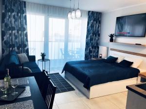 sypialnia z łóżkiem i salonem w obiekcie Kasprowicza 20 Luxury Apartments - Free Pool, Saunas, Salzgrotte, Jacuzzi, Gym, Children's Playroom, Fitness w Kołobrzegu