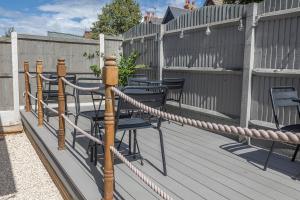 una terraza de madera con sillas y una cuerda en The Sleep-Inn Hare B&B en Herne Bay