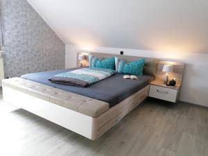 a bedroom with a large bed with blue pillows at Apartment Weber in Offenheim